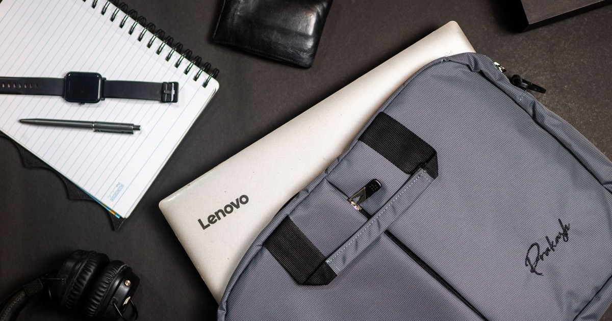Top view of modern office essentials including a laptop, notebook, and accessories.