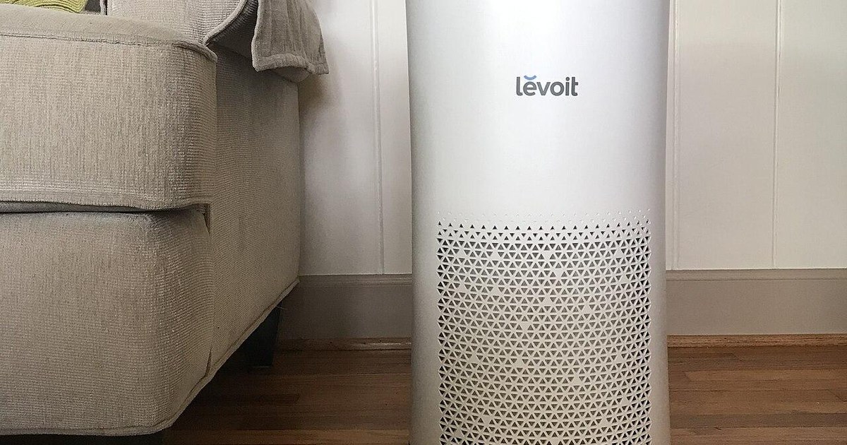 White air purifier beside a sofa in a living room