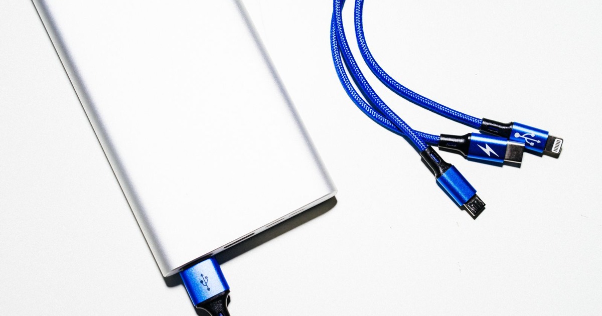 Minimalist image of a power bank with blue USB charging cables on a white background.