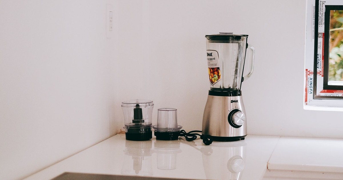 Stylish kitchen corner featuring a sleek blender and induction stove on a white countertop.