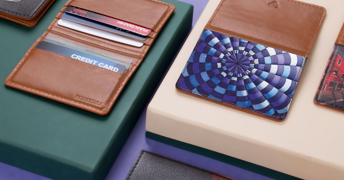 Close-up of assorted leather wallets and cardholders on a modern violet and green background.