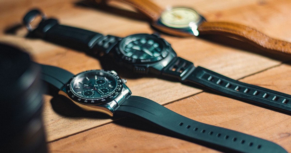 Close-up of elegant analog wristwatches on a wooden surface, showcasing style and craftsmanship.