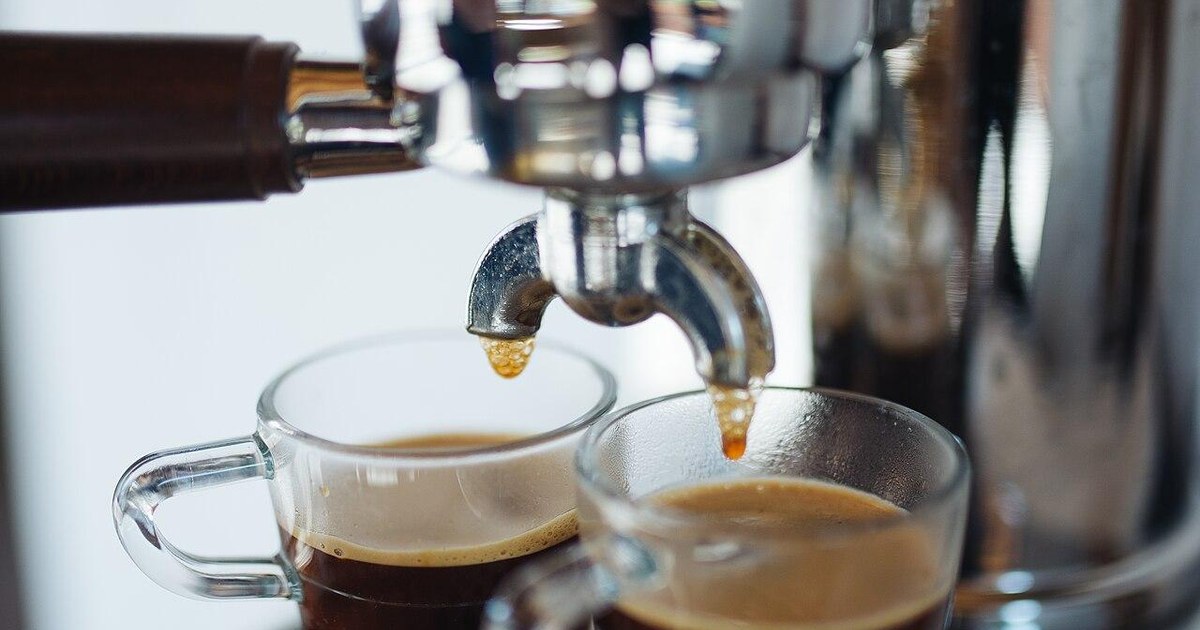 Espresso pouring from a coffee machine into two cups