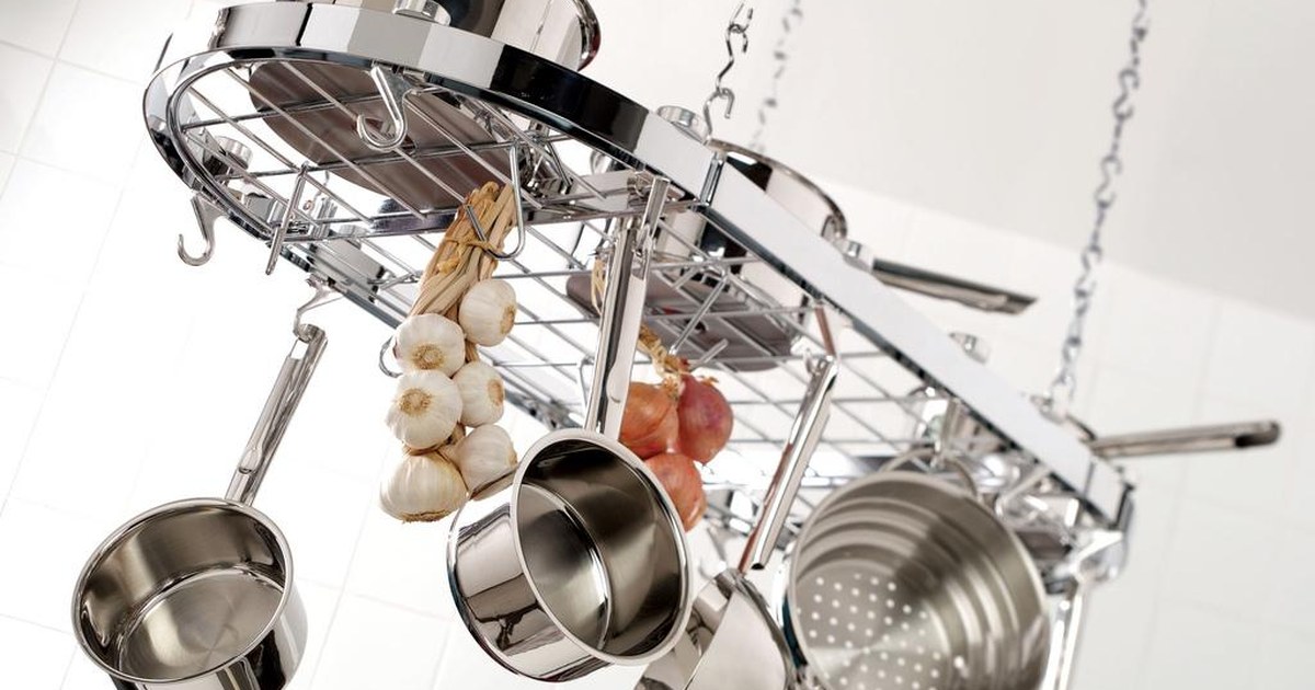 Stainless steel pots and pans hanging from a kitchen rack