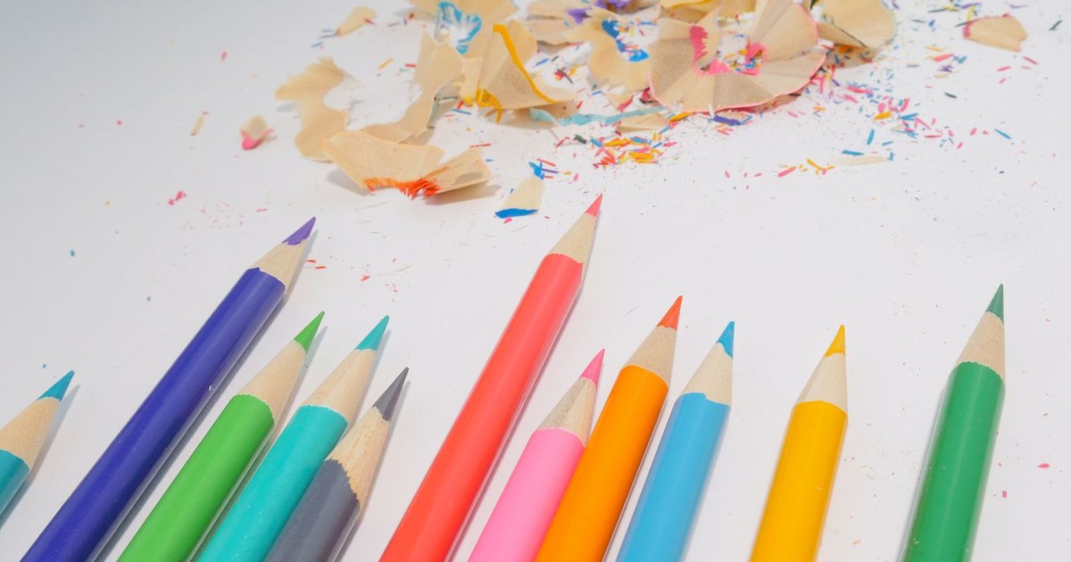 A collection of colorful pencils with shavings on a white background, ideal for creative projects.