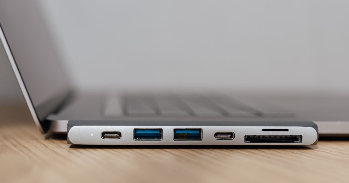 Space grey type c USB hub with multiple different ports connected to laptop